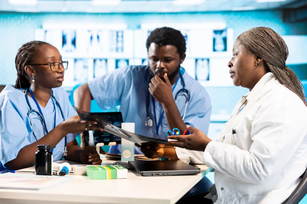 A senior clinician going through an X-ray with two nurses at a desk